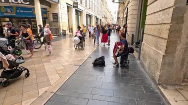 Meşgul caddede yoldan geçenler için akordeon çalar