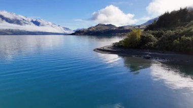 Wakatipu Gölü 'nün dingin sularının ve Yeni Zelanda' nın Glenorchy kentindeki berrak gökyüzünün altındaki dağların havadan görüntüsü.