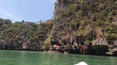 Bereketli, kayalık bir adanın sahil şeridinde süzülüyordu.