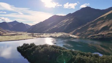 Moke Gölü 'nün yeni Zelanda, Queenstown' daki dingin güzelliğini, çarpıcı dağ yansımaları ve dinamik ışıklandırmalarıyla görüntüler.