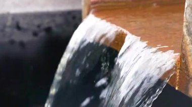 Su, ahşap bir barajın üzerinden akıyor.