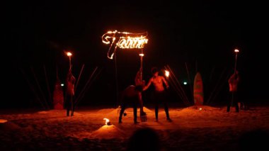 Karon Sahili 'ndeki dinamik yangın performansı, ateşli sahne donanımlı yetenekli sanatçıların, canlı bir gece arkaplanına karşı hazırlanması.