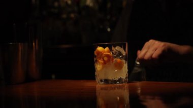 Barmen barda narenciye kokteyli hazırlıyor.