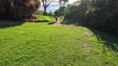 Çimenli bir yolda koşan bir baba ve çocuk