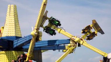 İnsanlar heyecan verici bir lunapark gezintisinin tadını çıkarıyor.