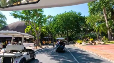 Ziyaretçiler Chonburi, Tayland 'daki Khao Kheow Açık Hayvanat Bahçesi' ni tramvayla geziyorlar. Bereketli yeşillik ve güneşli hava canlı bir atmosfer yaratır.