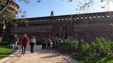 Sforzesco Kalesi girişinde yürüyen insanlar
