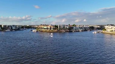 İnsansız hava aracı görüntüleri lüks mülkleri ve tekneleri Gold Coast 'un rıhtımında gün batımının altında yakalıyor.