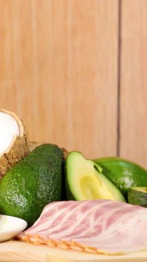 Sıcak ışık altında ahşap bir yüzeye yerleştirilmiş çeşitli sağlıklı yağ ve yağlar.