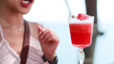 Karpuz suyunu pipetle yudumlayan bir kadın.