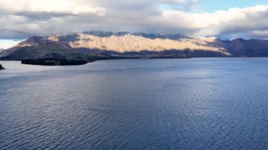 Hava görüntüleri Wakatipu Gölü 'nün sakin güzelliğini yakalıyor. Etrafı dağlarla çevrili, yumuşak akşam ışığı altında.