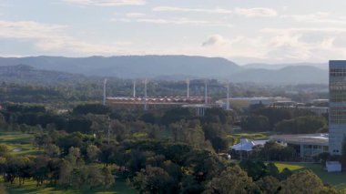 İnsansız hava aracı görüntüleri, Carrara Stadyumu ve çevresindeki yeşillikleri gündüz gözüyle gösteren Gold Coast 'un ufuk çizgisini yakalıyor.