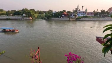 Bir tekne manzaralı bir nehir manzarasında yol alır.