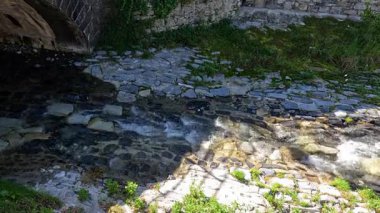 Su Varenna 'da taş bir köprünün altından akıyor.