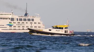 Bir pilot gemisi, Bellarine, Victoria yakınlarındaki sakin denizlerde feribota rehberlik ediyor. Açık gökyüzü ve sabit kamera denizcilik sahnesini çeker.