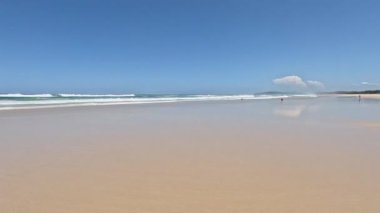 Güneşli bir sahilde hafif dalgaların zamanı.