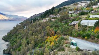 Hava görüntülerinde Queenstown 'un verimli tepeleri ve Wakatipu Gölü yumuşak gün ışığında canlı sonbahar yaprakları ve sakin manzaralar sergilenmektedir.