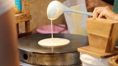 Kalabalık bir pazarda krep hazırlama süreci