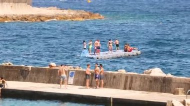 Denizde yüzen platformda bir grup insan