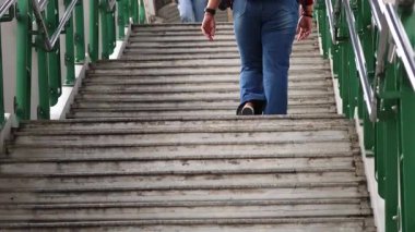 İnsanlar açık havada büyük bir merdivene tırmanıyorlar.