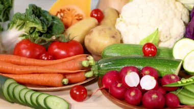 Taze sebzelerden oluşan canlı bir karışım, renklerini ve dokularını parlak bir ışık altında sergiliyor.