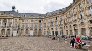 İnsanlar Bordeaux 'da tarihi bir meydanın keyfini çıkarıyor