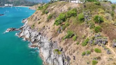 Phuket, Tayland 'daki Promthep Burnu' nun manzaralı kıyı şeridini ve yemyeşil yeşilliğini gün ışığında gösteren hava görüntüleri.