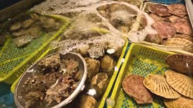 Mangal ızgarasında çeşitli deniz ürünleri cızırdıyor.