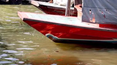 Yüzen ve suyun üzerinde hafifçe hareket eden kırmızı bir tekne