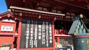 Ziyaretçiler, kırmızı yapıları olan tarihi bir tapınağı keşfediyorlar.