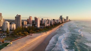 İnsansız hava aracı görüntüleri, gün doğumunda Gold Coast 'un ufuk çizgisini ve okyanus dalgalarını canlı renkleri ve sakin kıyı güzelliğini yakalar.