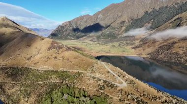 Moke Gölü 'nün, Yeni Zelanda, Queenstown' daki dingin manzarasını, dağların geniş manzarası ve yemyeşil