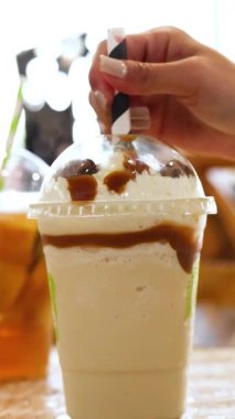 Bir bardağa köpüklü bir şarap dökülüyor, canlı yeşil bir zemin üzerine kuruluyor, kabarcıklar ve renkler vurgulanıyor.