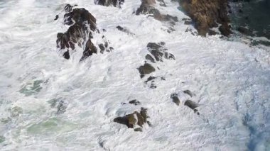 Dinamik hava görüntüleri, Avustralya 'nın Byron Körfezi' ndeki kayalıklara çarpan güçlü okyanus dalgalarını gün ışığında yakalıyor.