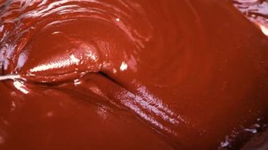 Yumuşak çikolata parçaları eriyip zengin bir sıvıya dönüşüyor.