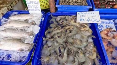 Kalabalık bir pazarda çeşitli deniz ürünleri sergileniyor