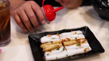 Erişteli pilavın üzerine sos dökülüyor.