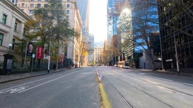 Binaları ve ağaçları olan boş bir sokak.