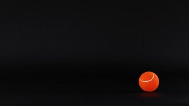 Tenis topu koyu arkaplanda yuvarlanıyor