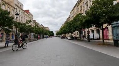 İnsanlar canlı bir şehir caddesinde geziniyor.