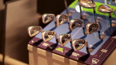 Askıdan golf sopası seçen kişi.