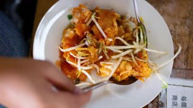 Yüzen bir pazarda geleneksel bir yemeğin tadını çıkarmak.