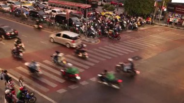 Araçlar ve motorsikletler yoğun bir kavşaktan geçiyor