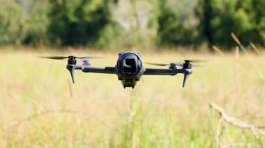 İnsansız hava aracı uçar ve çim tarlasının üzerinde uçar.