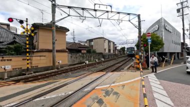Banliyö treni yaya yolundan geçiyor.