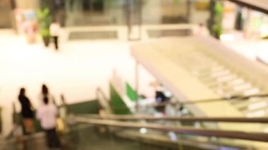 Kalabalık bir alışveriş merkezinde yürüyen insanlar.