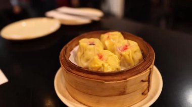 Hamur köfteleri masada bambu sepetinde servis edilir.