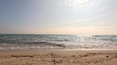 Yumuşak dalgalar kumsalda yuvarlanıyor