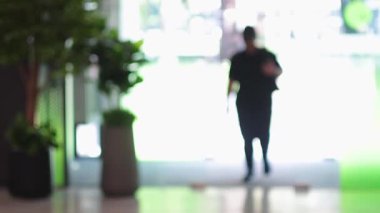 Alışveriş merkezinde kameraya doğru yürüyen kişi.