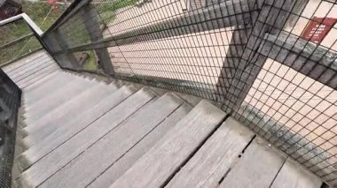 Çitlerle çevrili ahşap bir merdivenden aşağı yürüyorum.